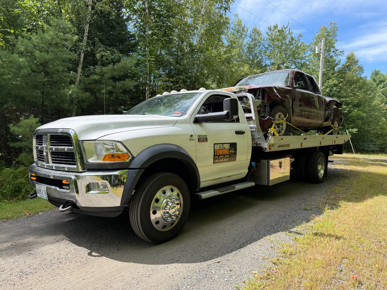 North Point Towing branded flatbed carrying a pickup truck